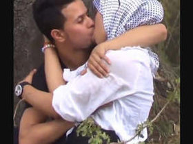 A passionate South Asian couple engages in outdoor foreplay with breast fondling and kissing